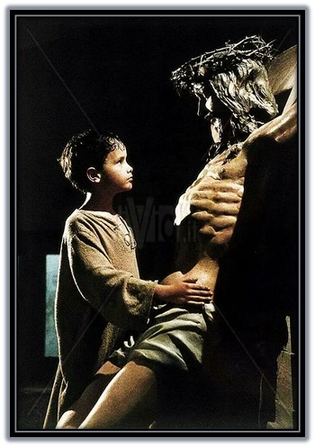 niño delante del crucifijo