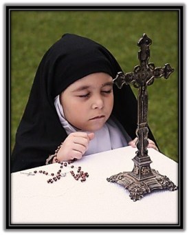 Niña con hábito de Carmelita en oración