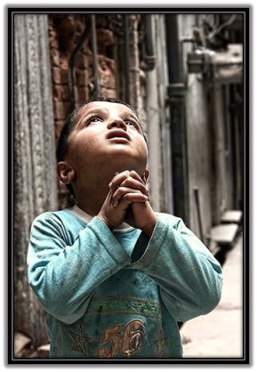 Niño rezando mirando al Cielo