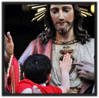 Niño tocando el Corazón de Jesús